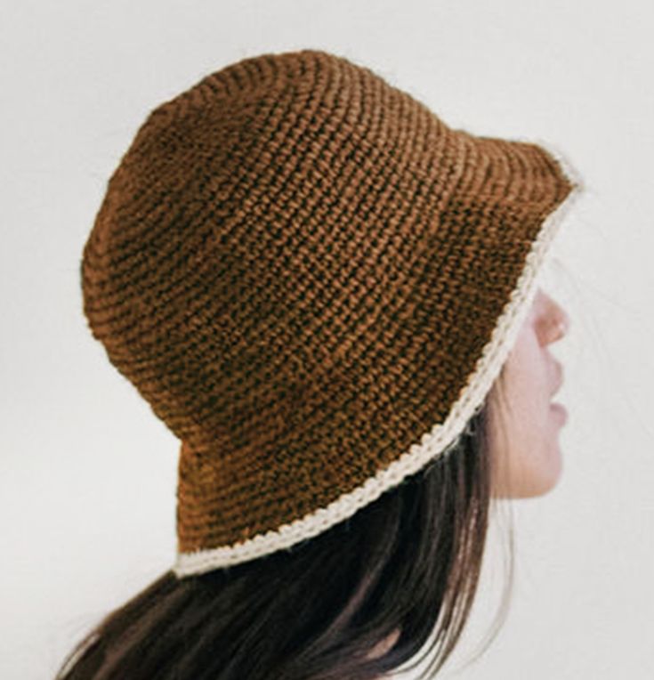 a woman wearing a brown knitted hat with a white stripe around the brim