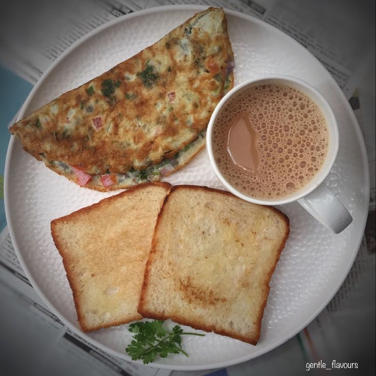 an omelet and toast on a plate with a cup of coffee