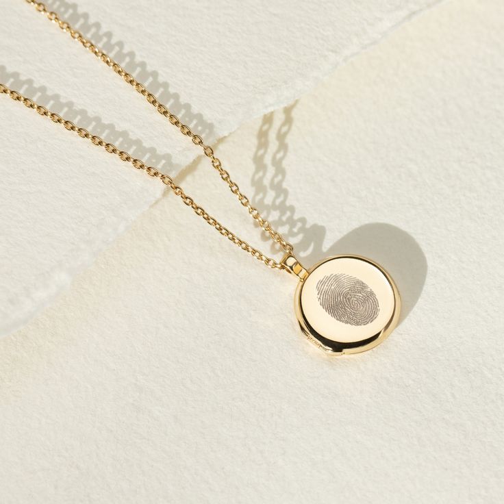 Every locket tells a story and our sterling silver lockets make the most meaningful personalised gift. Capture and enhance the beautiful detail of a fingerprint with our stunning locket necklace. The lines and grooves that make a fingerprint unique are enhanced and lasered onto the front of this stunning locket. Perfect for preserving something special from a child or remembering someone who is no longer with us. The inside can be personalised further and couldn't be simpler, just add text  (i.e. name or date) and one photo, or upload two photos, we'll take care of the rest! A highly polished locket with a hidden hinge ensures the flow of the circle isn't broken. The locket is 16mm flat with softly contoured edges and holds 12mm photos. * * * * * * * * * * * * * * * * * How we'll make your Minimalist Necklace With Engraving Option For Keepsake, Minimalist Keepsake Necklace With Engraving Option, Engraved Round Pendant Locket Necklace As Gift For Her, Minimalist Sterling Silver Locket Necklace, Timeless Round Locket Necklace As Gift, Timeless Engraved Locket Necklace As Gift, Sterling Silver Minimalist Locket Necklace As Gift, Minimalist Engraved Jewelry For Keepsake, Personalized Sterling Silver Locket Necklace As Gift For Her