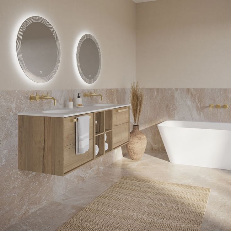 a bathroom with two round mirrors above the sinks and a bathtub in front of it