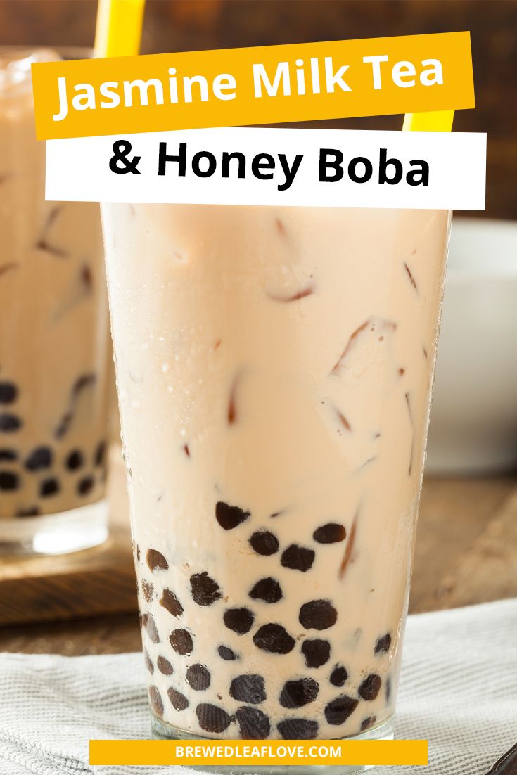 two glasses filled with milk and honey boba tea on top of a wooden table