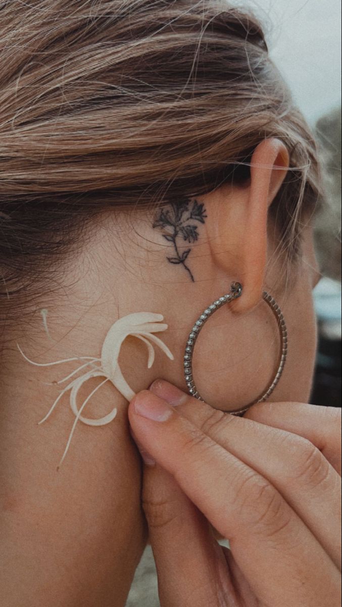 a woman with tattoos on her back ear