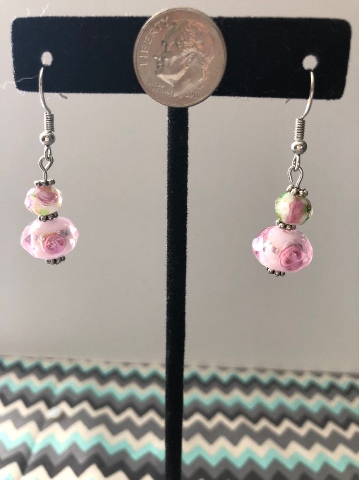 "Our colors are Blush and Bashful!" These pink and white earrings have small flowers inside. A hint of green and silver is present to help solidify any floral ensemble! Pink Earrings With Ear Wire For Spring, Spring Pink Earrings With Flower Charm, Pink Flower Earrings With Ear Wire For Spring, Pink Drop Earrings For Spring, Elegant Pink Hypoallergenic Flower Earrings, Pink Beaded Earrings For Spring Gift, Pink Round Jewelry For Spring, Pink Floral Print Jewelry As Gift, Nickel-free Round Pink Flower Earrings