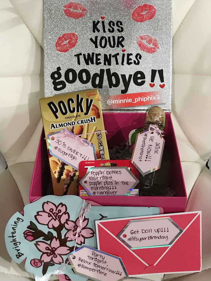 a pink box filled with lots of goodies on top of a white chair next to a sign that says kiss your twenties goodbye rock around the clock