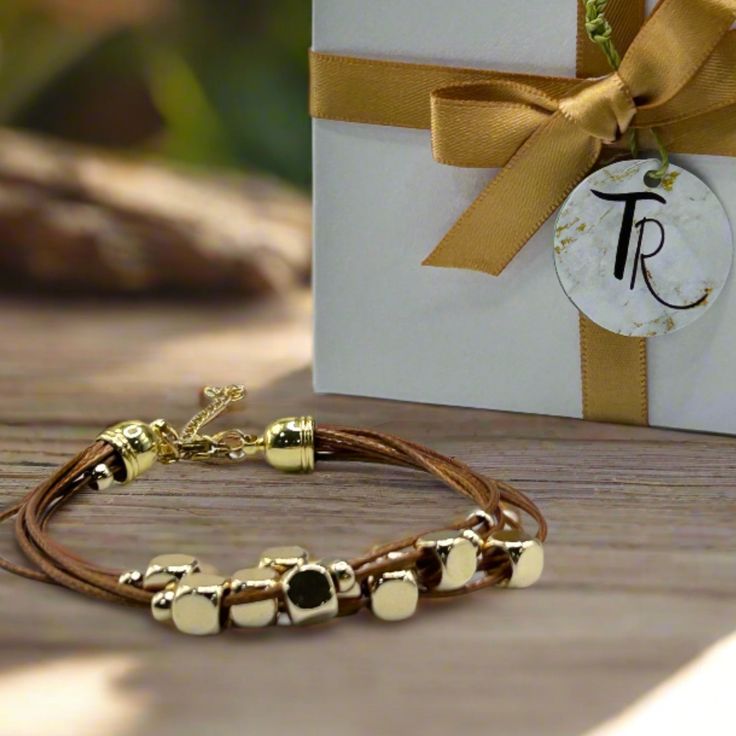 Get ready to elevate your wrist game with this multi-strand leather bracelet. Featuring gold-plated floating beads and a lobster clasp closure, this timeless piece is the perfect way to add a touch of sophistication to any outfit. Length: 6.5" + 1.5" extender chain - for an adjustable fit Lobster clasp closure - for a secure fit 6 strands of brown leather - for the perfect boho vibe 18K PVD Gold plated stainless steel - long lasting plating and hypoallergenic Handmade in China - to bring you the Adjustable Gold Leather Bracelet Chic Style, Adjustable Gold Leather Chic Bracelet, Adjustable Gold-tone Metal Beaded Bracelet, Elegant Multi-strand Adjustable Wrap Bracelet, Chic Leather Bracelet Jewelry, Gold Adjustable Double Strand Beaded Bracelets, Adjustable Multi-strand Metal Bracelets, Gold Wrap Bracelet Fashion Accessory, Elegant Gold Metal Wrap Bracelet