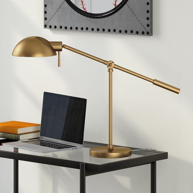 a laptop computer sitting on top of a desk next to a lamp and baseball ball