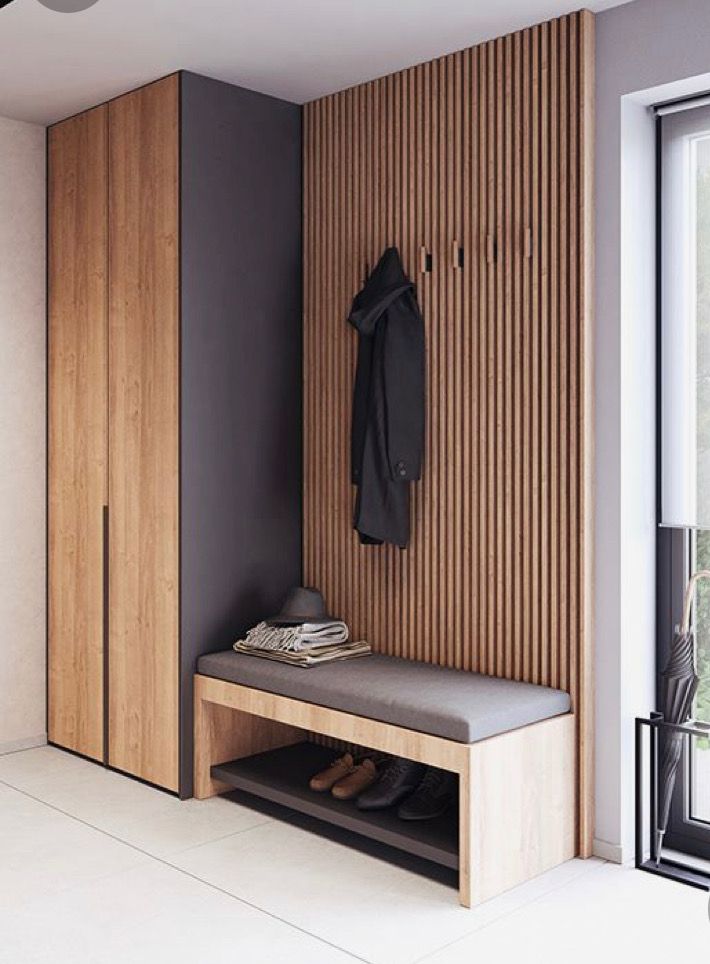 a wooden bench sitting next to a coat rack