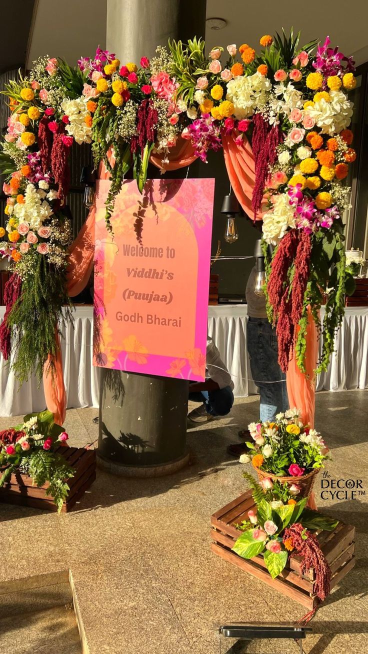 an arrangement of flowers on display in front of a sign