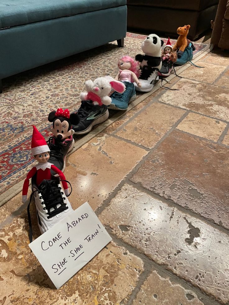 there are many stuffed animals lined up on the floor next to a sign that says come home