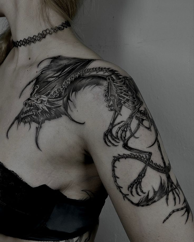 a woman with a dragon tattoo on her arm and chest, wearing a black bra