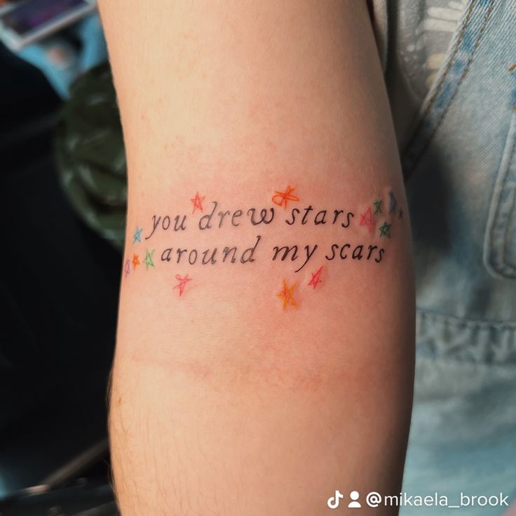 a person with a tattoo that says you drew stars around my scars on their arm