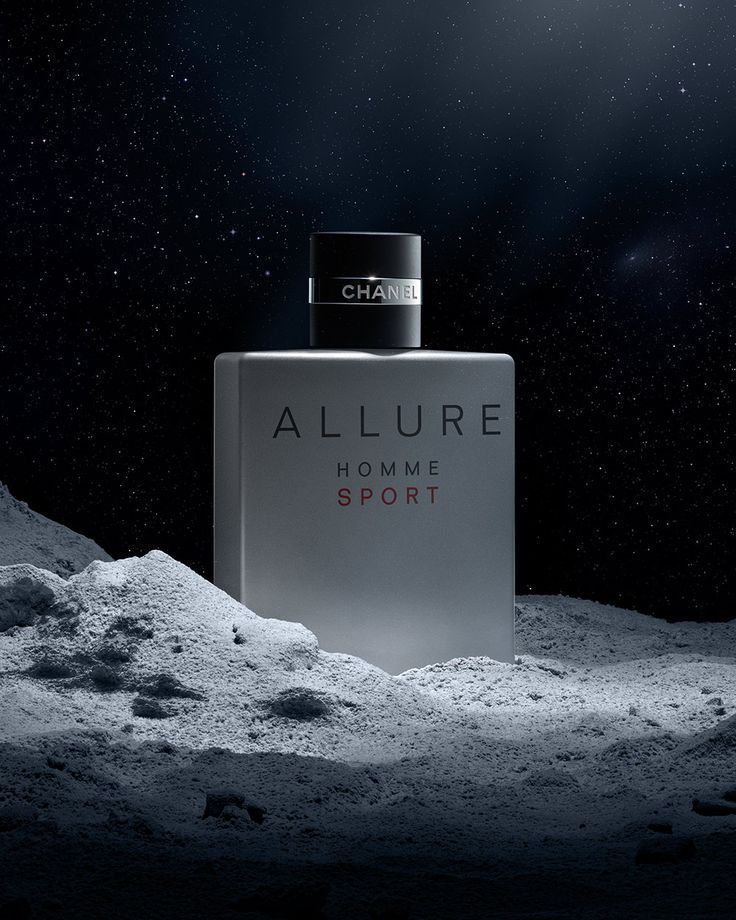 an allure perfume bottle sitting on top of a pile of snow next to the moon