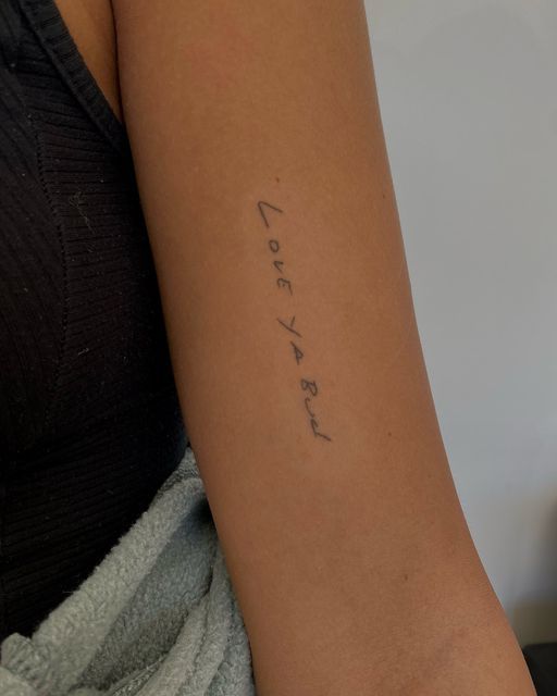 a woman's arm with the word love written in cursive writing on it