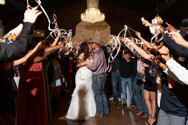 a group of people standing around each other at a party with streamers in the air