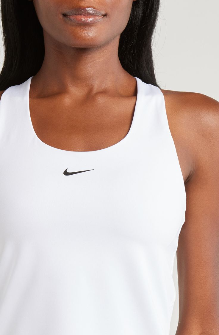 A built-in shelf-bra keeps you supported in this racerback tank top cut with signature Dri-FIT technology for cool, dry comfort as you work up a sweat. 20 1/2" length (size medium) Scoop neck Racerback Built-in shelf-bra Dri-FIT moisture-wicking technology 82% polyester, 18% spandex Machine wash, line dry Imported Nike Tops For Light Sports, White Racerback Top With Mesh Back, White Mesh Back Racerback Top, White Racerback Running Top, Breathable White Racerback Top, White Breathable Racerback Tank Top, White Breathable Racerback Top, White Sporty Tank Top With Mesh Back, White Racerback Tank Top With Mesh Back