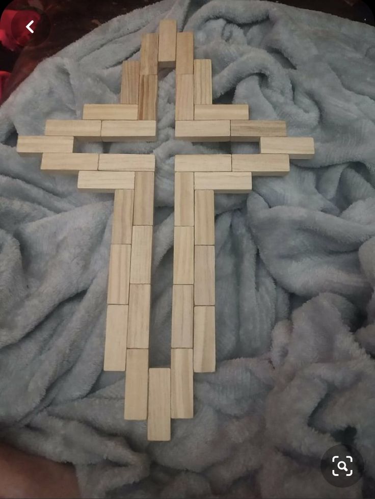 a wooden cross laying on top of a blanket