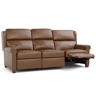 a brown leather reclining sofa and footstool with an ottoman on the side