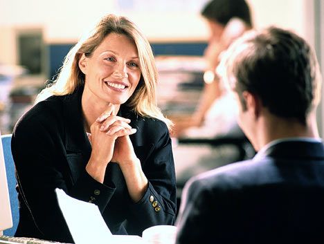 a woman sitting at a desk in front of a man