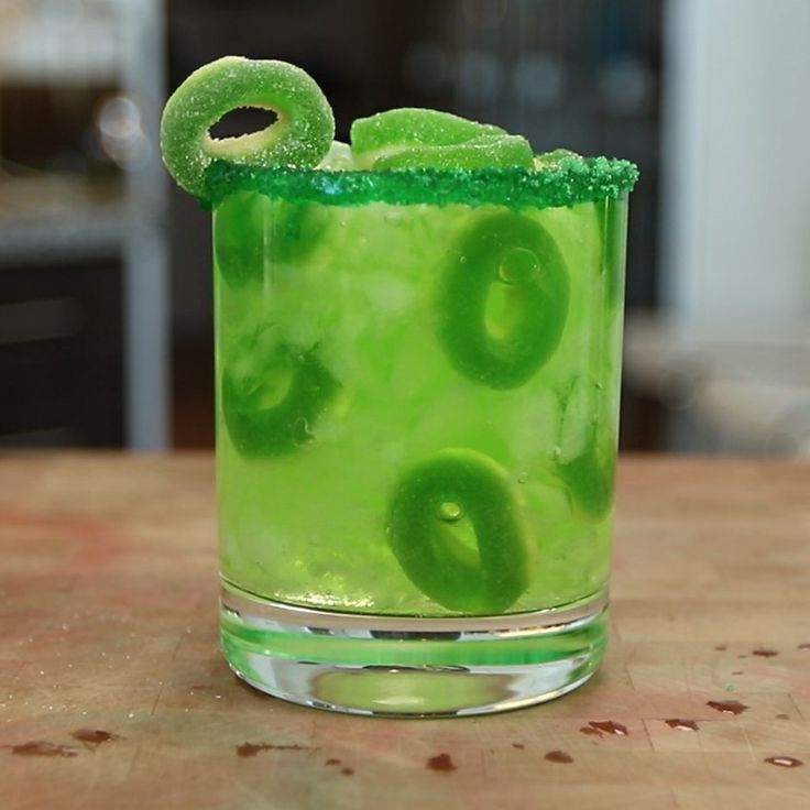 a green drink with lime slices on the rim