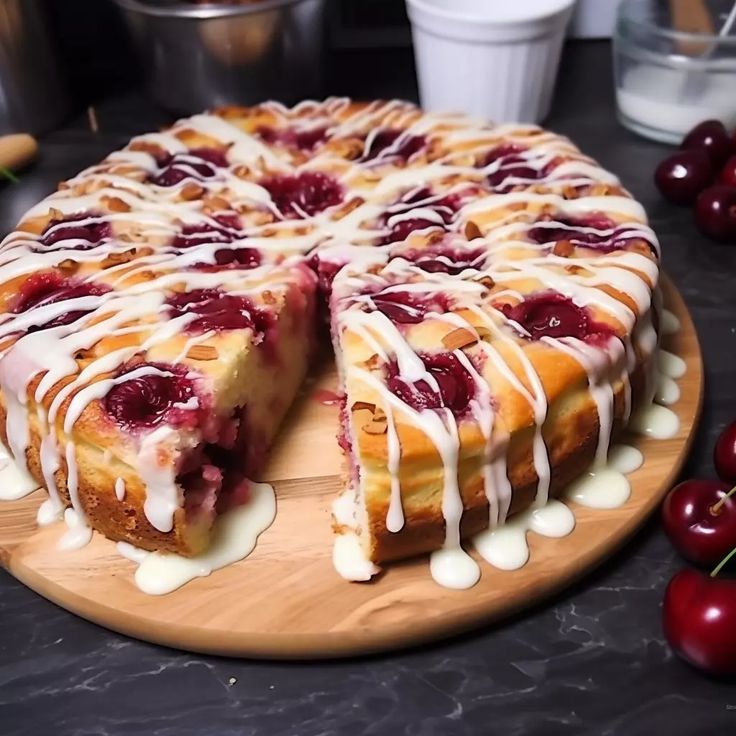 a cake with white icing and cherries sitting on top of a wooden platter