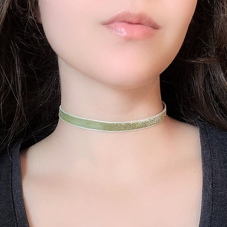 "A light green thin choker featuring glitter velvet ribbon and bronze hardware. The length shown in photos is 12\" and more options are available. Each size comes with an additional 2.5\" extender chain. For best fit, measure around the smallest part of your neck (close to center) and choose the next smallest size. If you would like a different length, send me a message and I can make that for you :) Ribbon clamps, lobster clasp, chain and charms are antique bronze tone alloy. Jewelry Care Tips Glitter Choker, Fairycore Necklace, Green Choker, World Necklace, Velvet Choker Necklaces, Velvet Choker, Victorian Gold, Bronze Hardware, Rose Necklace