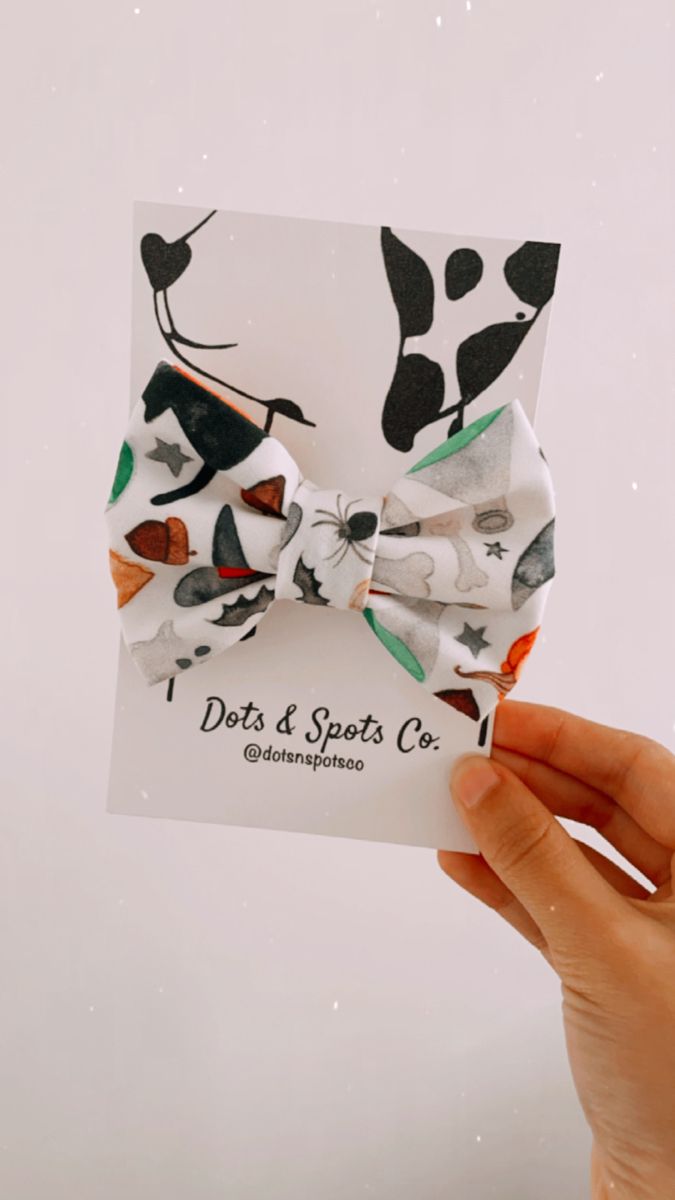 a person holding up a card with a bow tie on it's front and side