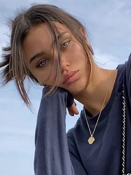 a woman is posing with her hair in the wind