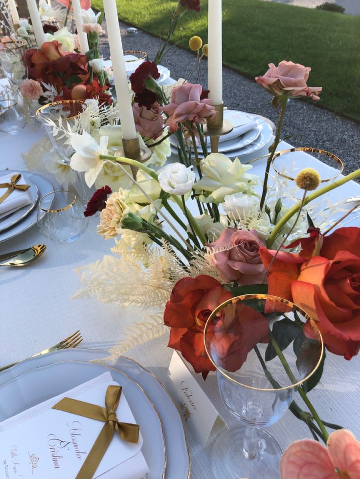 the table is set with flowers and place settings