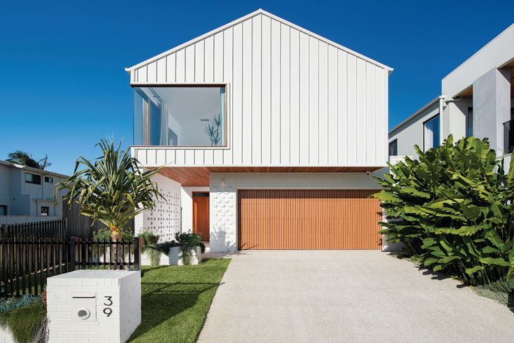 a white house with wooden garage doors and windows