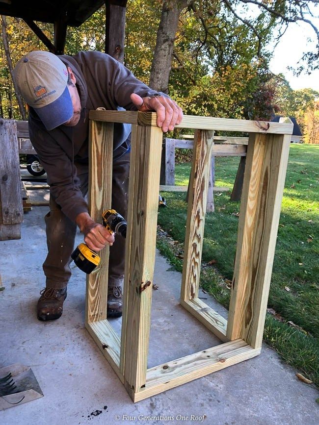 a man working on framing a wooden frame