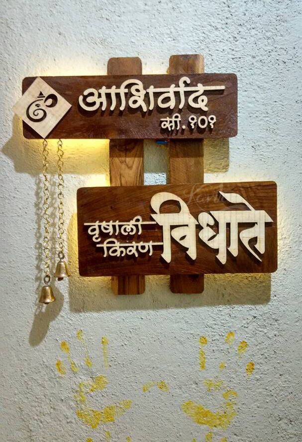 two wooden signs mounted to the side of a wall next to a chain hanging from a hook