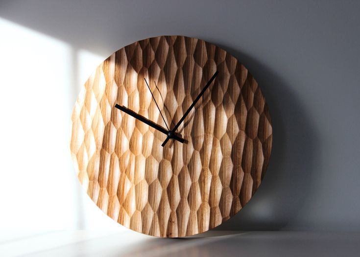 a wooden clock with black hands on a white wall