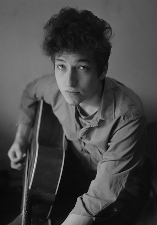 an old black and white photo of a person holding a guitar