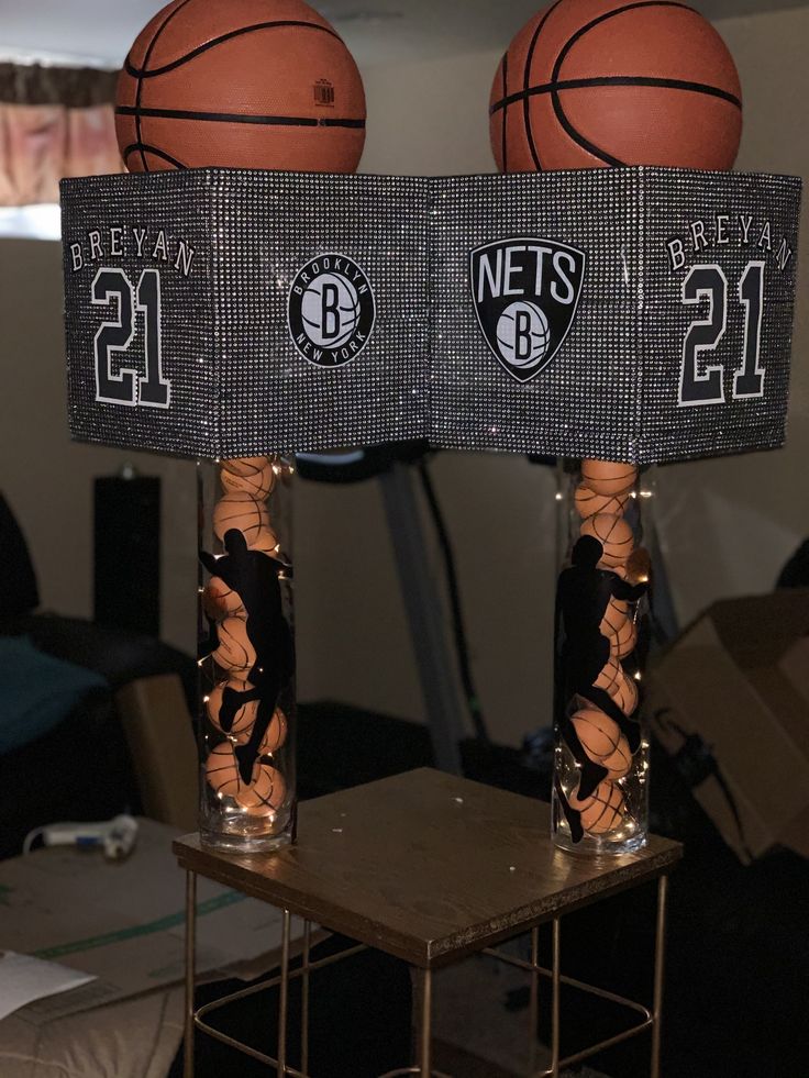 two glass vases with basketballs on top of each other in front of a table