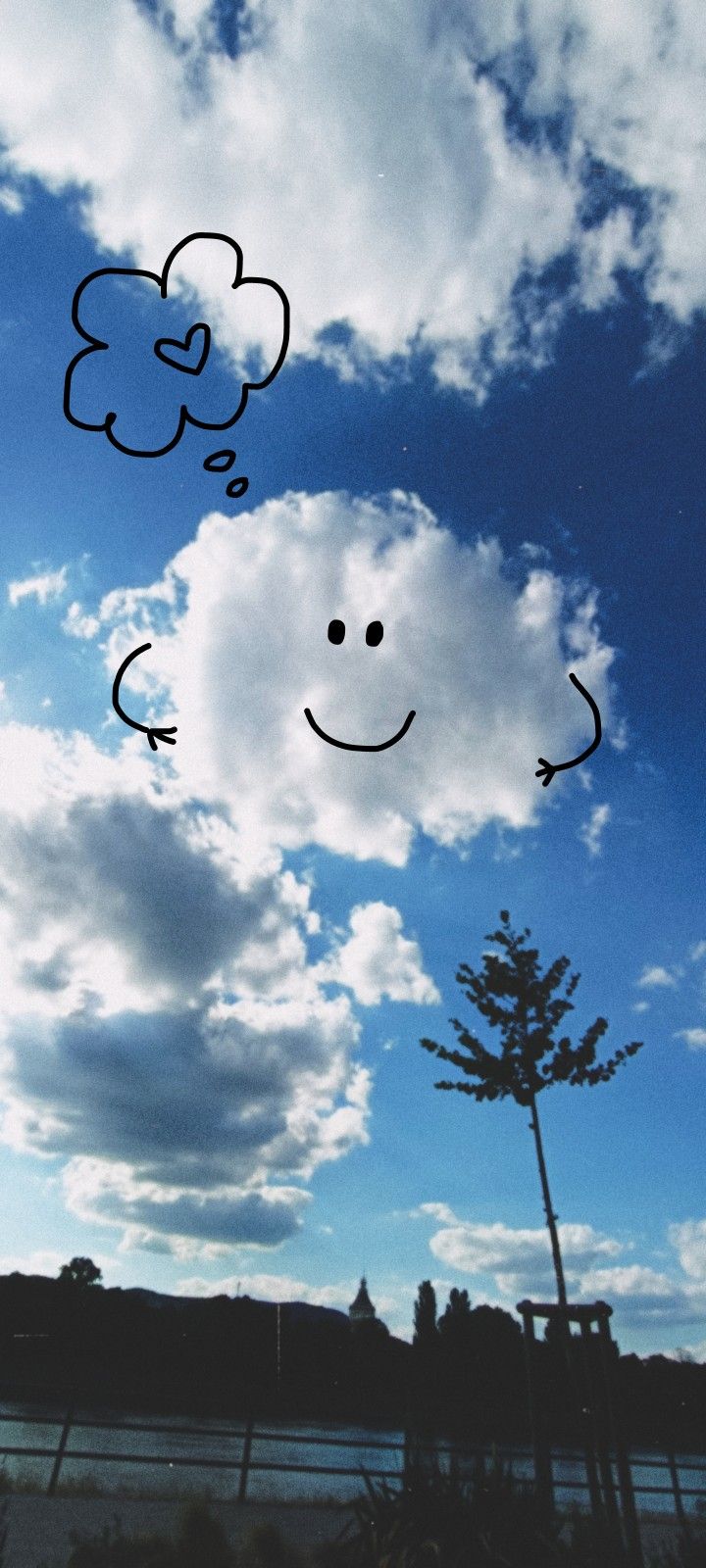 the sky is filled with clouds and smiling faces