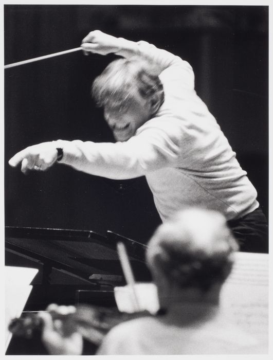 an old photo of a man playing the piano and conductor in front of him with his arms outstretched