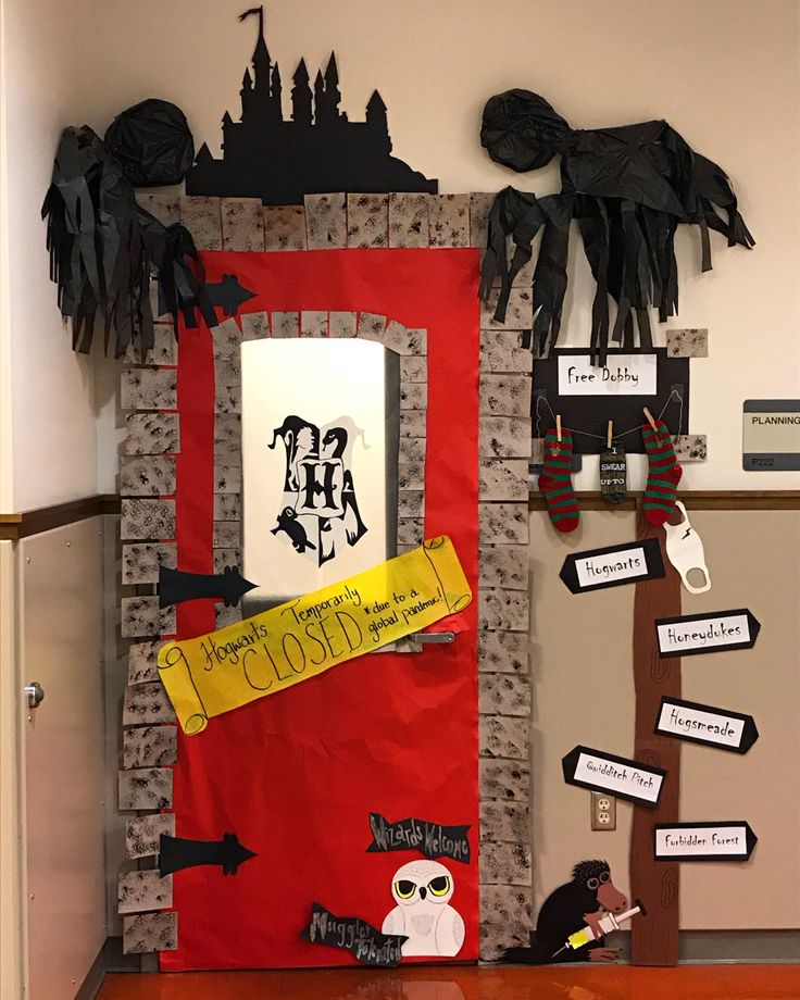 a red door decorated with halloween decorations and paper mache on it's side