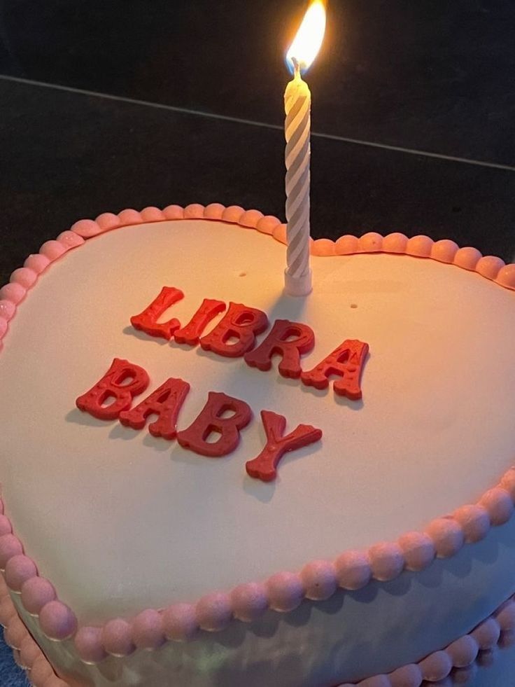 a birthday cake with the words libera baby on it and a lit candle