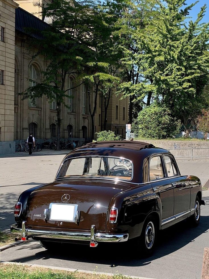 an old car is parked on the side of the road