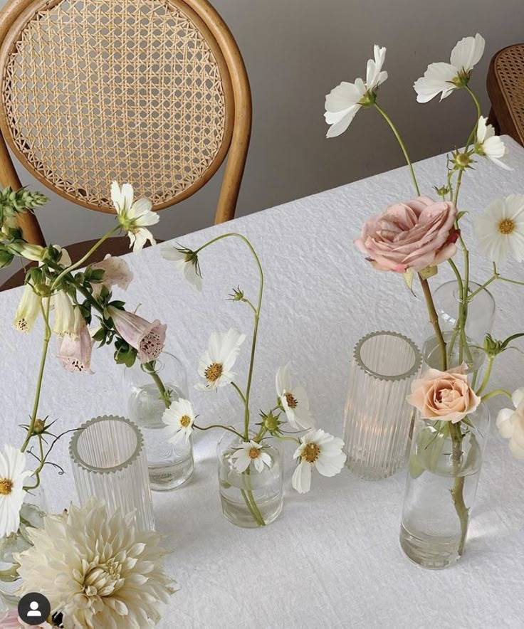 several vases filled with flowers sit on a table