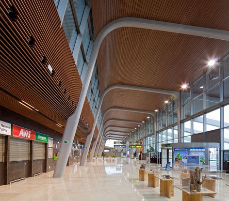 the inside of an airport terminal with lots of glass walls and ceiling lights on either side