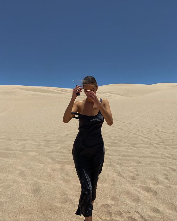 a woman standing on top of a sandy beach