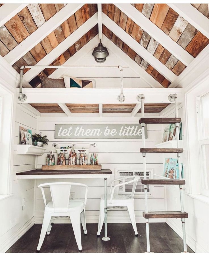 the inside of a small room with white furniture and wood paneling on the ceiling