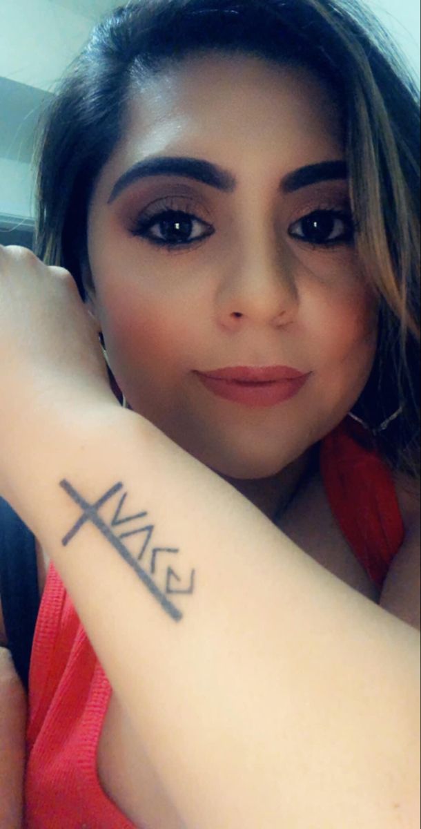 a woman with a cross tattoo on her arm