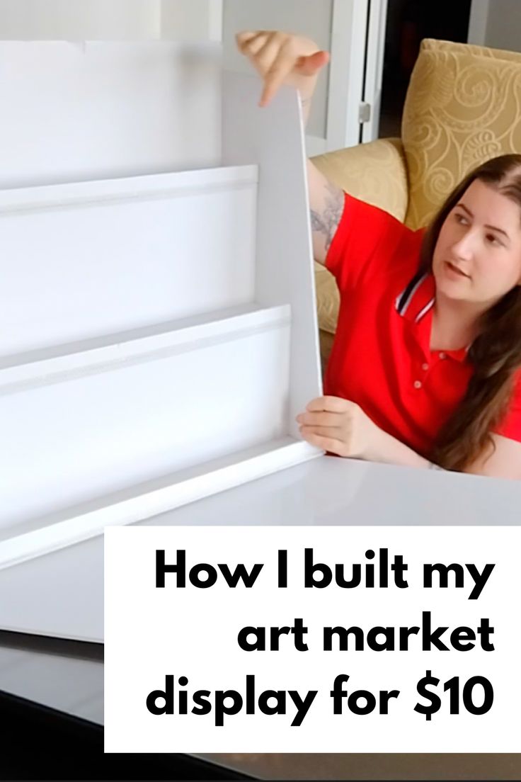 a woman sitting in a chair holding up a sign that says, how i built my art market display for $ 10