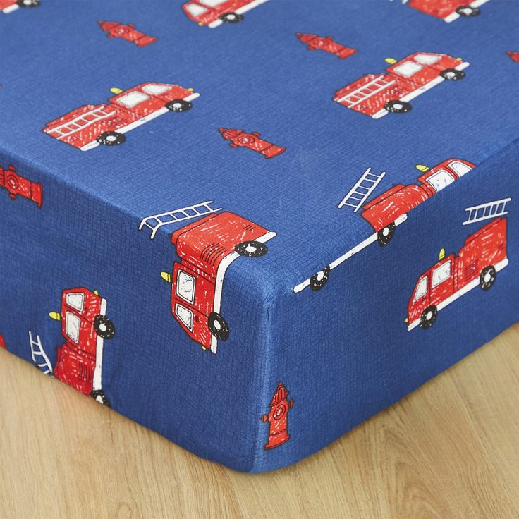 a blue sheet with red firetrucks on it