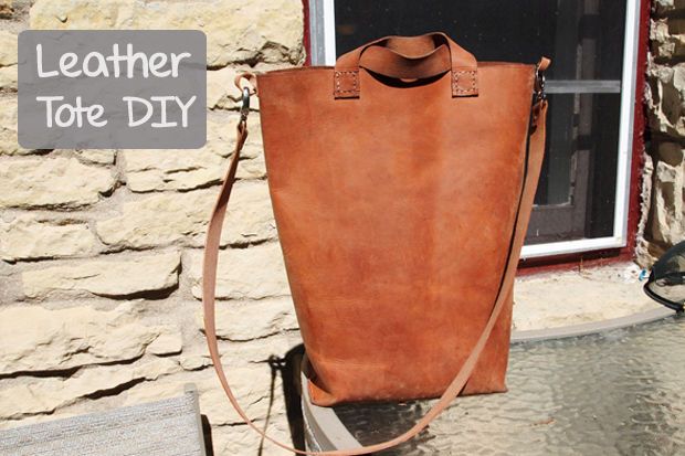 a brown leather tote bag sitting next to a window