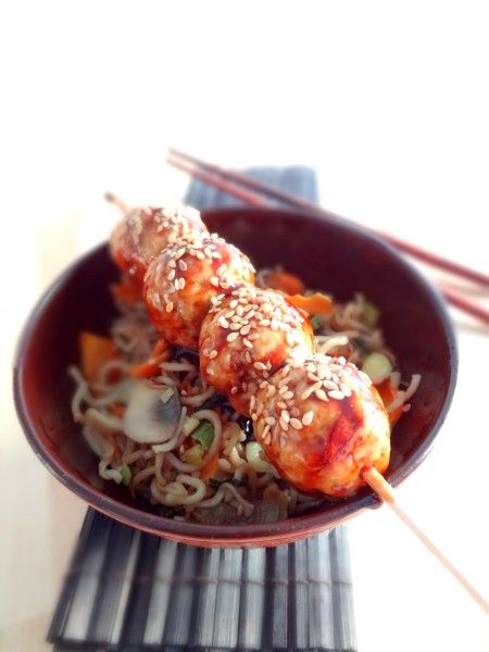 a bowl filled with meat and vegetables covered in sesame seeds