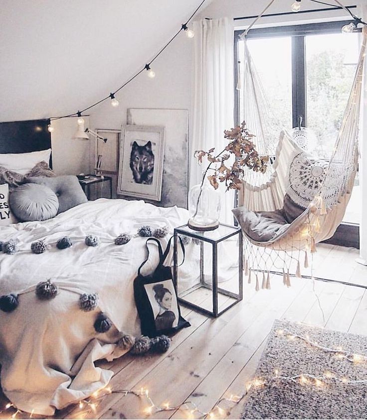 a bedroom with a hammock hanging from the ceiling and pillows on the bed