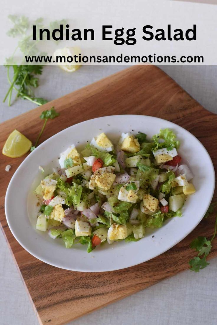 a white plate topped with salad on top of a wooden cutting board next to a lemon wedge